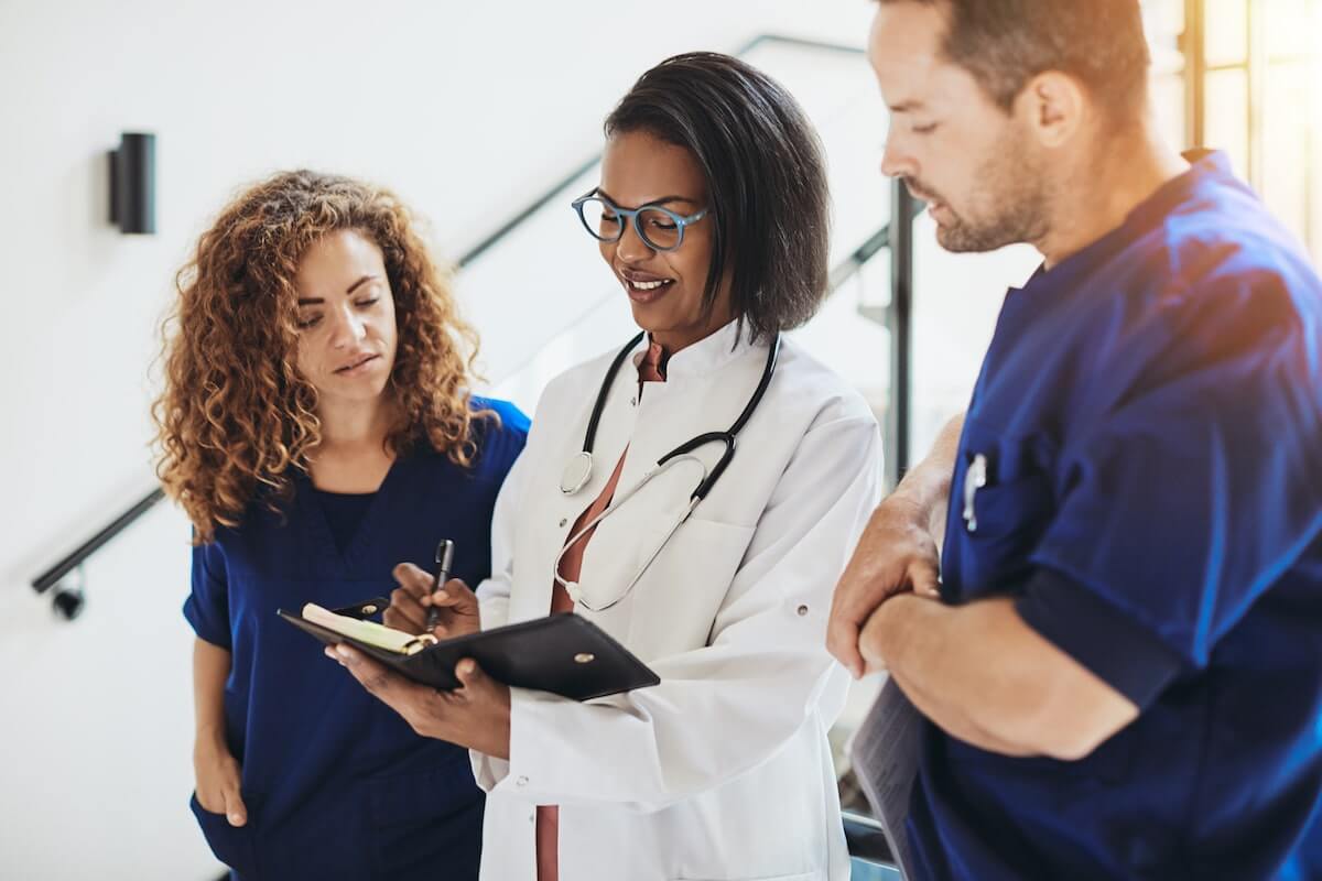 diverse doctors conferencing in hospital hallway